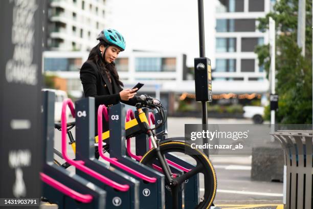 woman in urban station with electric bike and commuting around city. - new zealand city people stock pictures, royalty-free photos & images