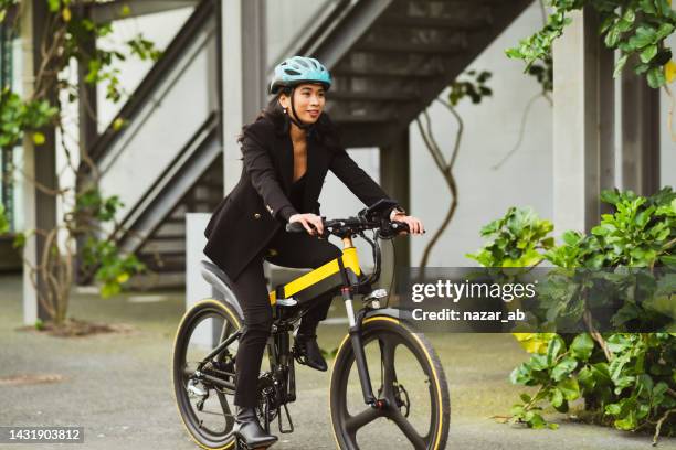 riding electric bicycle to work. - sustainable transportation stock pictures, royalty-free photos & images