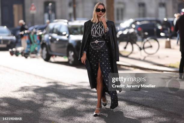 Candela Pelizza seen wearing a Chanel dress with slot, a leather coat and black shades, outside Chanel during Paris Fashion Week on October 04, 2022...