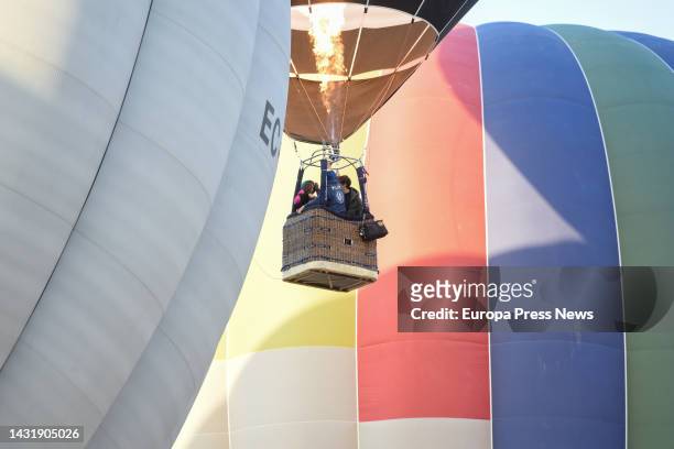 Several people ride on the barge of a zeppelin in flight during the Hot Air Balloon Festival, October 9 in Aranjuez, Madrid, Spain. This free show is...