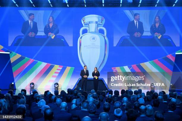 Hosts Pedro Pinto and Laura Wontorra speak during the UEFA EURO 2024 qualifying round draw at Messe Frankfurt on October 09, 2022 in Frankfurt am...