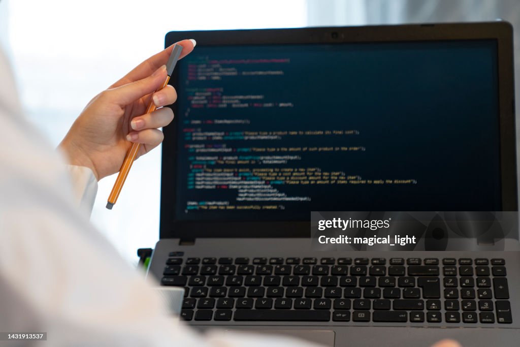 Programador desde atrás y programación de código en monitor de ordenador