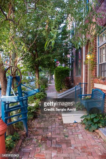 terraced brick townhouses with front stoopsand basement door on a brick pavement - philadelphia apartment townhouses stock pictures, royalty-free photos & images