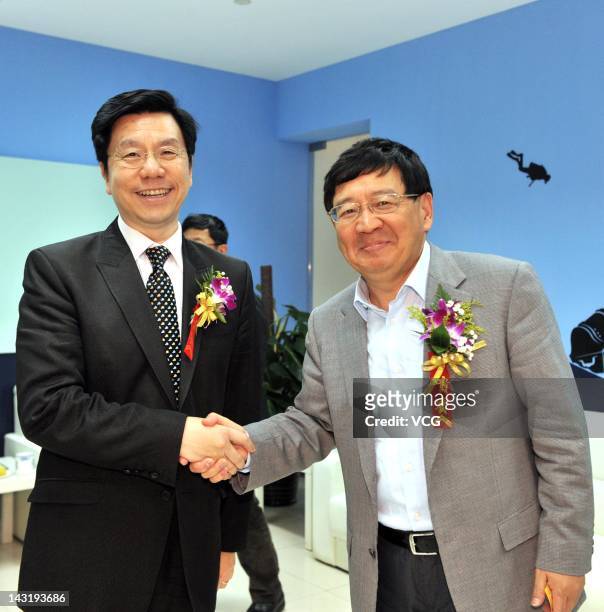 Kai-Fu Lee , chairman and chief executive officer of Innovation Works, shakes hands with Xu Xiaoping, a famous Chinese angel investor, during...
