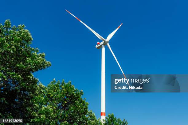 wind turbines on green field against blue sky - paper windmill stock pictures, royalty-free photos & images