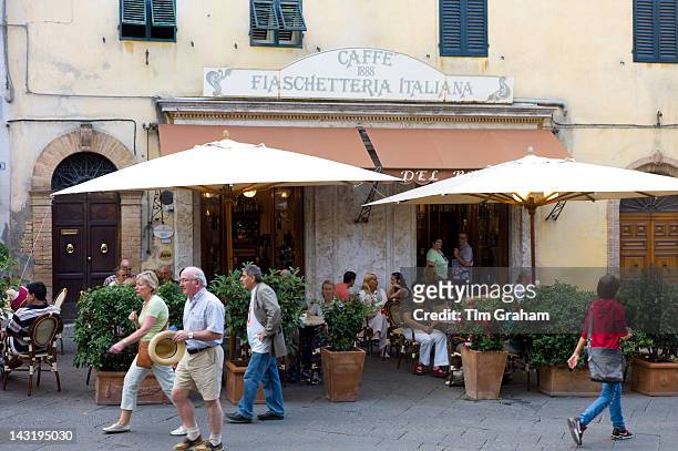 Diners eat al fresco at restaurant and bar Caffe 1888 Fiaschetteria Italiana in Piazza del Popolo, Montalcino, Val D'Orcia,Tuscany, Italy