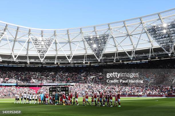 Players of Fulham and West Ham United line up in front of the 'No Room For Racism' handshake board prior to the Premier League match between West Ham...