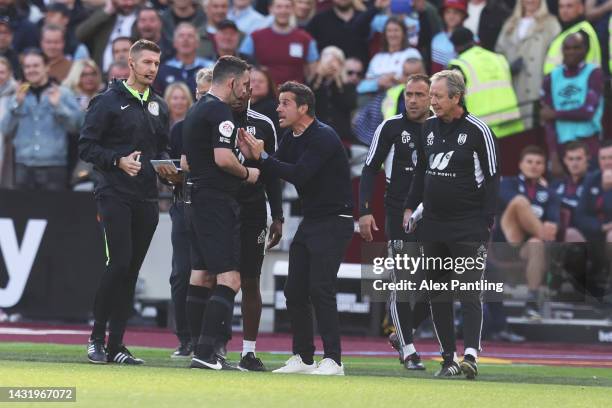 Referee Chris Kavanagh shows a yellow card to Marco Silva, Head Coach of Fulham after Gianluca Scamacca of West Ham United scored their sides second...