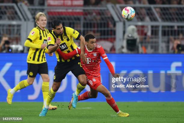 Jamal Musiala of Bayern Muenchen is challenged by Emre Can of Borussia Dortmund during the Bundesliga match between Borussia Dortmund and FC Bayern...