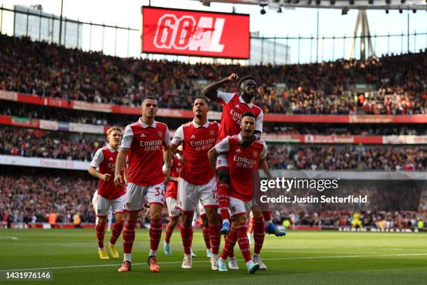 Gabriel Martinelli of Arsenal celebrates with teammates after scoring their team's first goal during the Premier League match between Arsenal FC and...