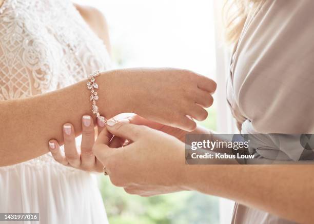 la mariée de mariage et la demoiselle d’honneur aident avec le bracelet de bijoux pour un glamour de mode élégant et classique. accessoire de diamant de mariée coûteux pour un style chic lors d’un événement spécial le jour de la cérémonie. - attacher photos et images de collection