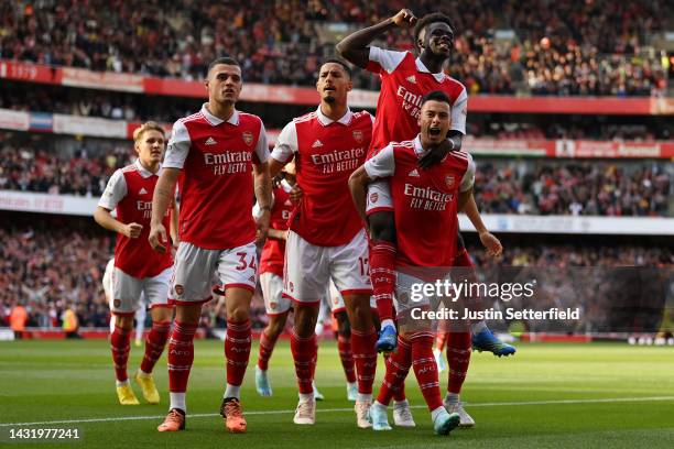 Gabriel Martinelli of Arsenal celebrates with teammates after scoring their team's first goal during the Premier League match between Arsenal FC and...