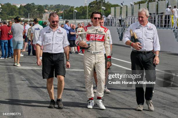 Driver Marco Fumagalli walks in the pits area holding a trophy during the last day of Estoril Classics in Fernanda Pires da Silva Estoril Circuit on...