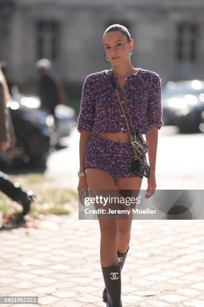 Fashion week guest seen wearing matching purple and pink patterned shorts and sweater with a Chanel bag, outside Chanel during Paris Fashion Week on...