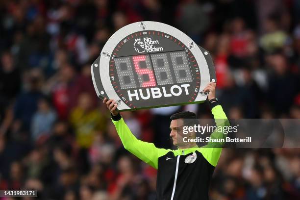 Fourth official Andy Madley lifts the 'No Room For Racism' substitution LED board during the Premier League match between Arsenal FC and Liverpool FC...