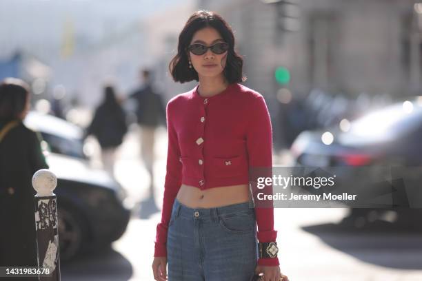 Fashion week guest seen wearing a red cropped sweater by Chanel, a Chanel pink fluffy bag and jeans, outside Chanel during Paris Fashion Week on...