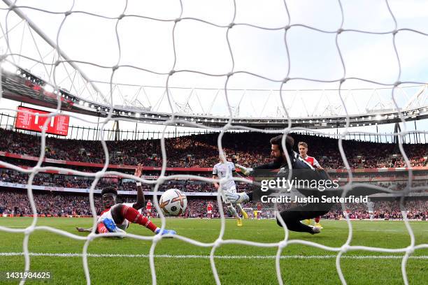 Bukayo Saka of Arsenal scores their team's second goal past Alisson Becker of Liverpool during the Premier League match between Arsenal FC and...