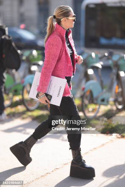 Fashion week guest seen wearing a pink blazer by Chanel, outside Chanel during Paris Fashion Week on October 04, 2022 in Paris, France.