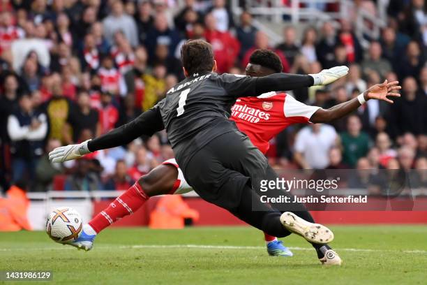 Bukayo Saka of Arsenal scores their team's second goal past Alisson Becker of Liverpool during the Premier League match between Arsenal FC and...