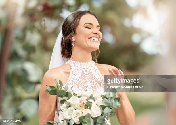 excited bride in wedding with bouquet in nature park with green trees, bokeh and summer sunshine. happiness, commitment and dream of a beauty woman with flowers for marriage in outdoor lens flare - 新娘 個照片及圖片檔