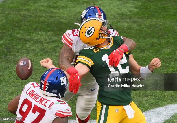 Aaron Rodgers of the Green Bay Packers is sacked by Oshane Ximines of the New York Giants and fumbles the ball in the fourth quarter during the NFL...