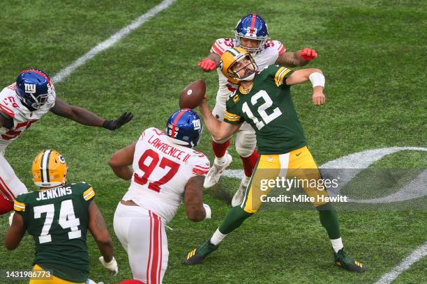 Aaron Rodgers of the Green Bay Packers is sacked by Oshane Ximines of the New York Giants and fumbles the ball in the fourth quarter during the NFL...