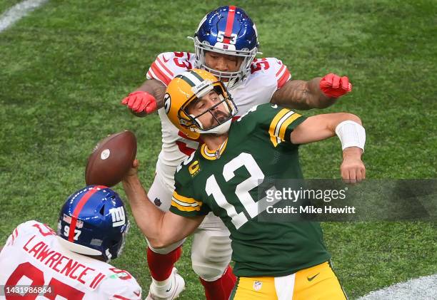 Aaron Rodgers of the Green Bay Packers is sacked by Oshane Ximines of the New York Giants and fumbles the ball in the fourth quarter during the NFL...