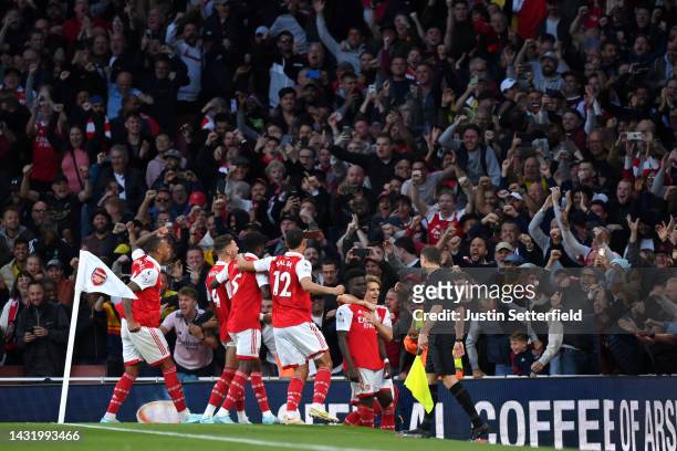 Bukayo Saka of Arsenal celebrates with teammates after scoring their team's third goal from the penalty spot during the Premier League match between...