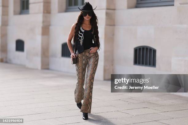 Sabina Jakubowicz seen wearing a Louis Vuitton petite malle bag, big shades by Gucci, Gucci animal print pants, a gold and black vest by Louis...