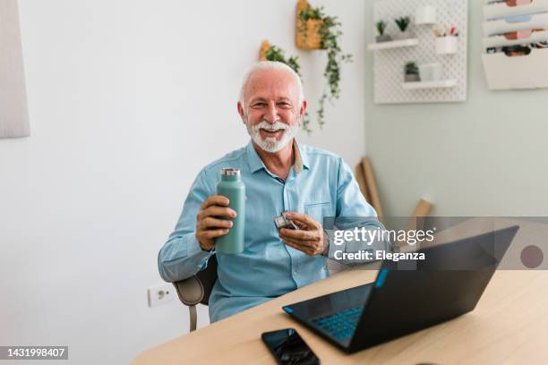 portrait of senior businessman drinking water from reusable bottle - reusable water bottle office stock pictures, royalty-free photos & images