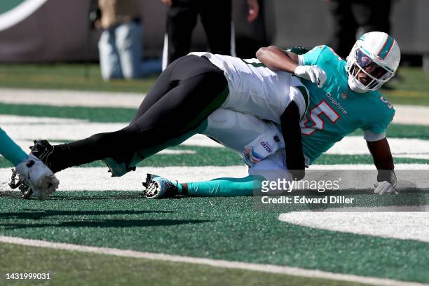 Sauce Gardner of the New York Jets tackles Teddy Bridgewater of the Miami Dolphins in the endzone for a safety during the first quarter at MetLife...