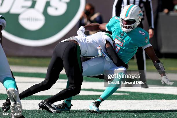 Sauce Gardner of the New York Jets tackles Teddy Bridgewater of the Miami Dolphins in the endzone for a safety during the first quarter at MetLife...