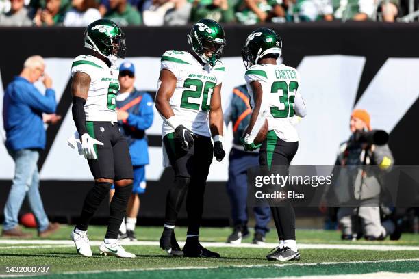 Michael Carter of the New York Jets is congratulated by teammate Breece Hall after scoring a touchdown against the Miami Dolphins during the second...