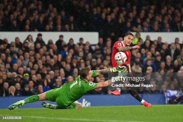 Antony of Manchester United scores their team's first goal past Jordan Pickford of Everton during the Premier League match between Everton FC and...