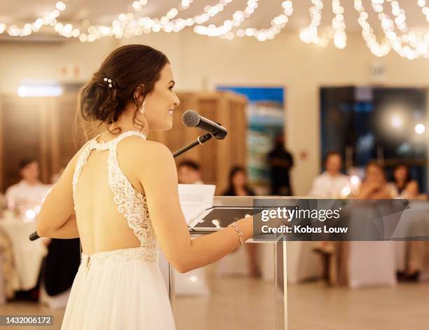 wedding speech and happy bride with microphone speaking to marriage party reception guests. cheerful and caring married woman love story presentation at banquet with friends and family. - wedding party stock pictures, royalty-free photos & images