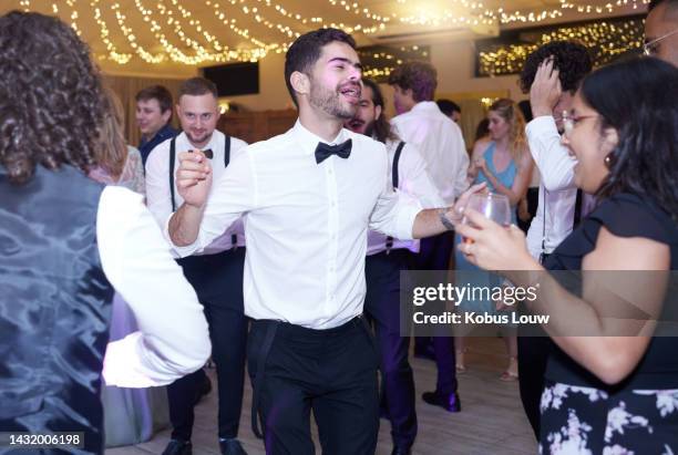 drunk wedding group dancing to music on the dance floor of the celebration reception or event. guests and people having fun while singing and drinking with a song at a marriage disco after party. - after party stockfoto's en -beelden