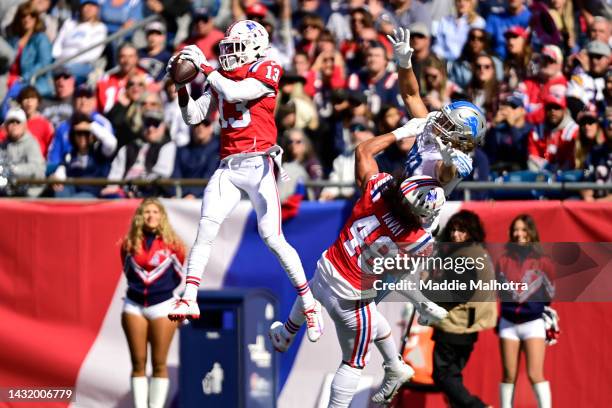 Jack Jones of the New England Patriots intercepts a pass intended for T.J. Hockenson of the Detroit Lions while Jahlani Tavai of the New England...