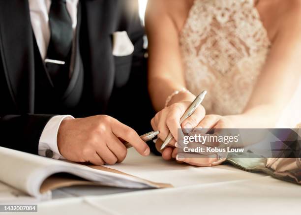 couple sign wedding certificate, marriage registration and document paper for legal union. closeup bride, groom and hands writing contract for celebration of love, commitment and agreement together - trouwerij stockfoto's en -beelden