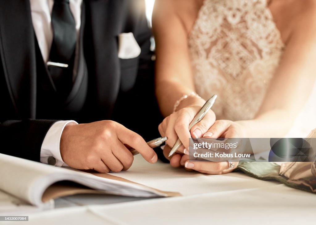 Couple sign wedding certificate, marriage registration and document paper for legal union. Closeup bride, groom and hands writing contract for celebration of love, commitment and agreement together