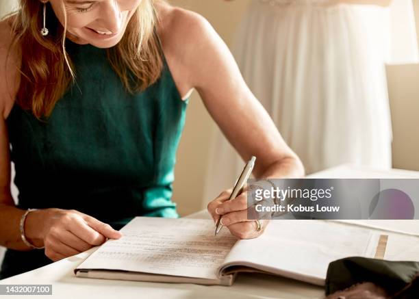 woman witness, signature and marriage contract, happy and smiling with pen and paper. bridesmaid signing legal documents at wedding ceremony. agreement, registration and a maid of honor with a smile. - 50s woman writing at table imagens e fotografias de stock