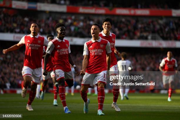 Gabriel Martinelli of Arsenal celebrates with teammates after scoring their team's first goal during the Premier League match between Arsenal FC and...