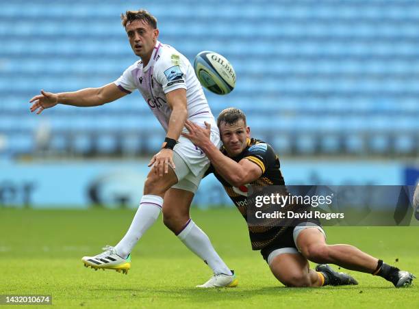 Alex Mitchell of Northampton Saints passes the ball as Ryan Mills challenges during the Gallagher Premiership Rugby match between Wasps and...