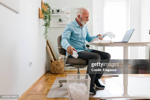 senior businessman throwing crumpled paper into a wastepaper basket at office - bin stock pictures, royalty-free photos & images