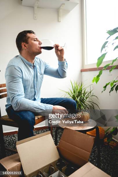 man sitting in the balcony and drinking wine. - wine home delivery stock pictures, royalty-free photos & images