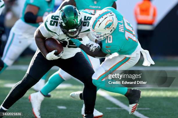 Quinnen Williams of the New York Jets is tackled by Tyreek Hill of the Miami Dolphins after recovering a fumble during the second half at MetLife...