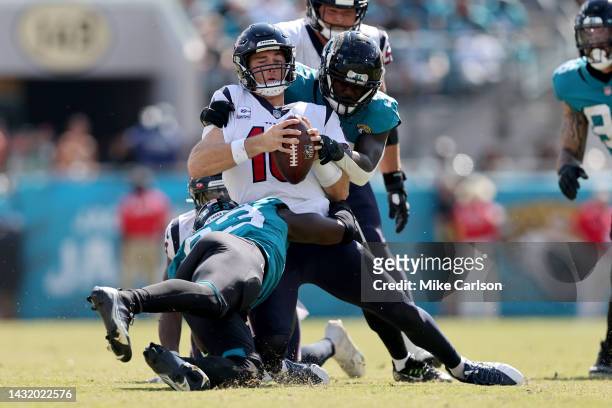 Davis Mills of the Houston Texans is tackled in the second half of the game against the Jacksonville Jaguars at TIAA Bank Field on October 09, 2022...
