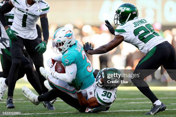 Myles Gaskin of the Miami Dolphins is tackled by Michael Carter II of the New York Jets during the fourth quarter at MetLife Stadium on October 09,...