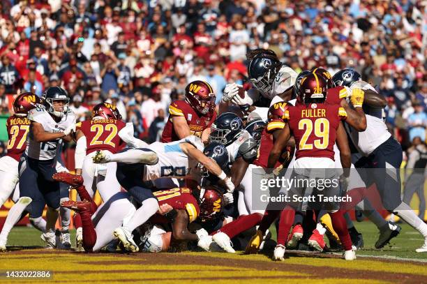 Derrick Henry of the Tennessee Titans leaps over a pile to score a touchdown during the third quarter against the Washington Commanders at FedExField...