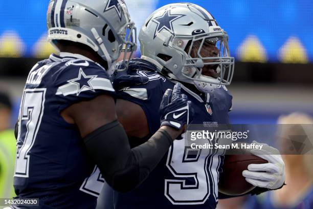 DeMarcus Lawrence of the Dallas Cowboys celebrates a fumble recovery for a touchdown with teammatyes against the Los Angeles Rams during the first...