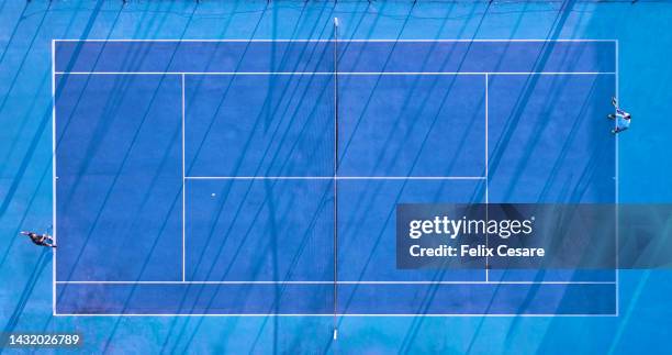 aerial view of two tennis players on a blue tennis court. - friendly match stock pictures, royalty-free photos & images